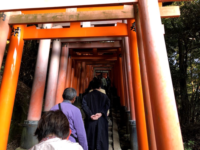 伏見稲荷大社の千本鳥居を登るお年寄り